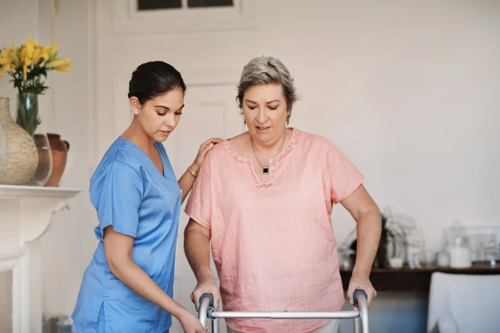 Aged woman holding her walking aid with her nurse