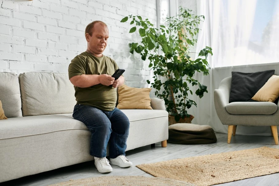 A disabled man looking at his phone while sitting down